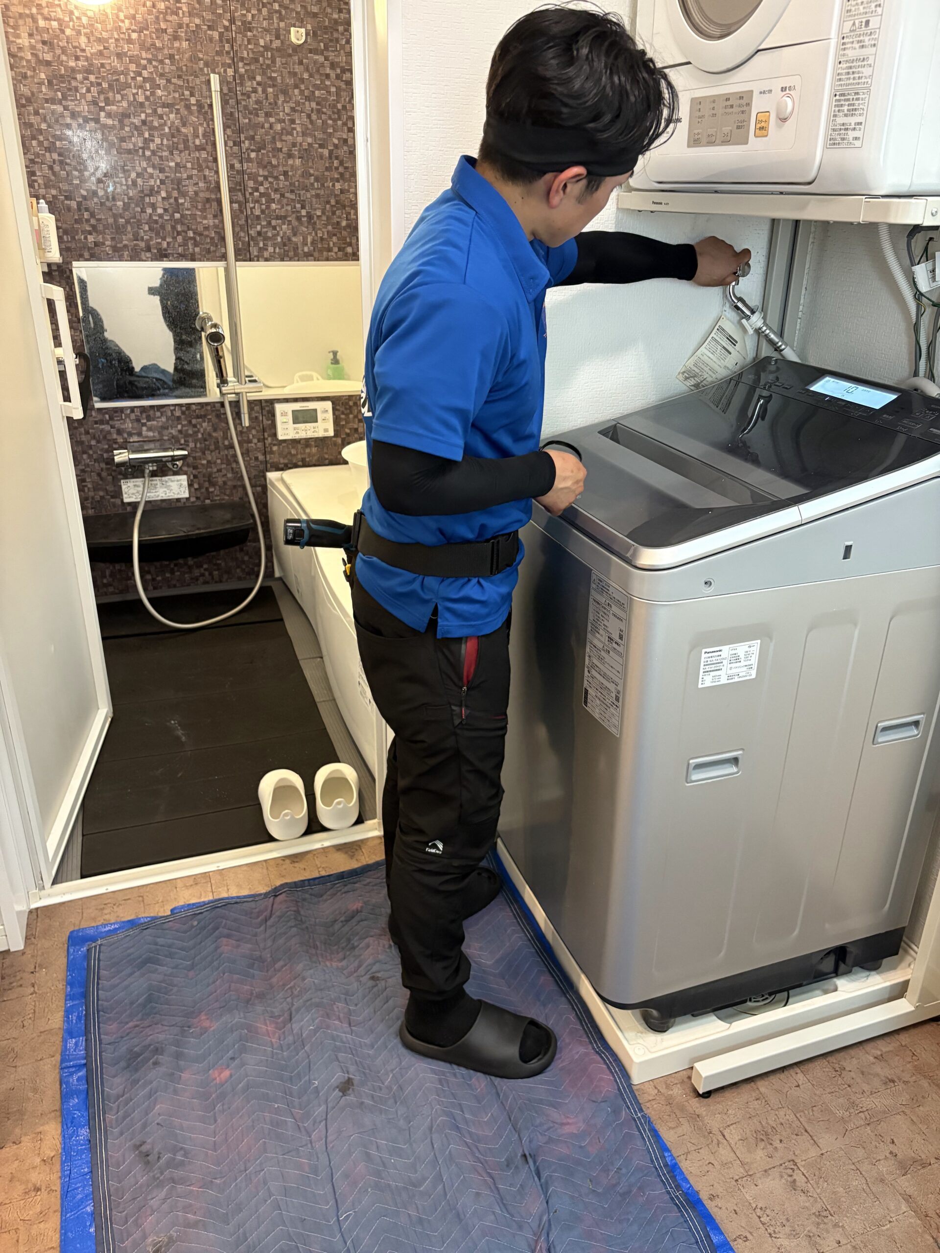 給水ホースや電源を外し、洗濯機を移動させる作業